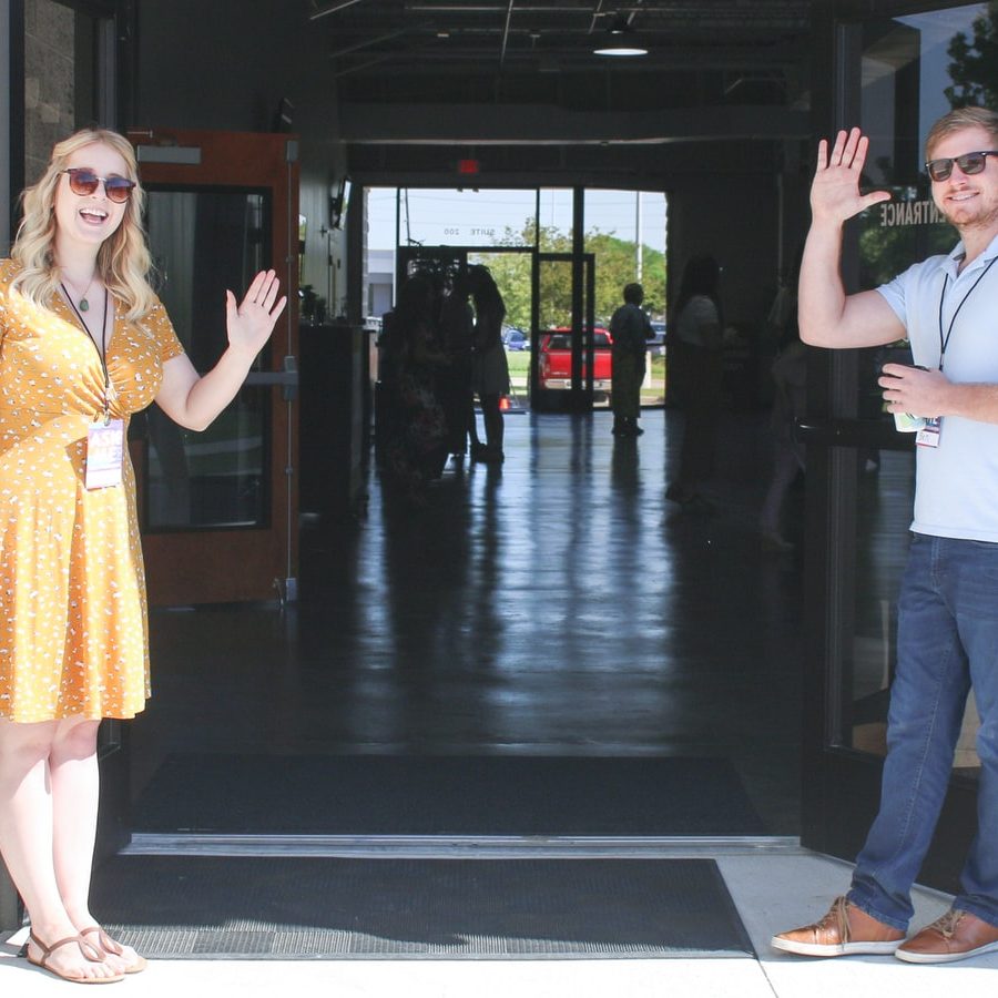 two man and woman standing on doorway